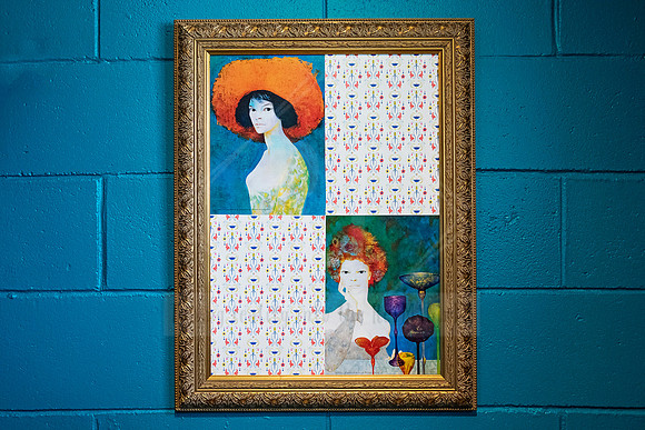 Framed painting with two whimsical female figures on bright blue wall, photographed inside Sunset Framing & Gallery.