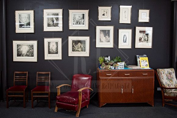 Interior photography of Sunset Framing & Gallery, highlighting artwork wall and styled seating area for business promotion.