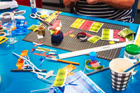 Creative workspace with embellishments and supplies for a handmade gift tag workshop.