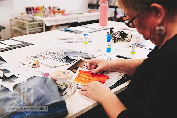 Hands creating paper collage artwork during a workshop.