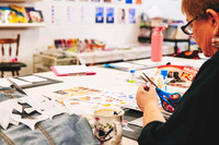 Participant selecting materials for a paper collage artwork.