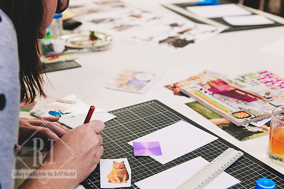 Close-up of hands working on a collage artwork.
