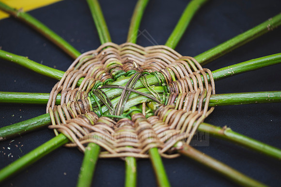 Overhead view of finished woven circle piece made from natural reeds, captured for creative business content.