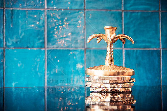 Golden palm tree ornament against deep turquoise feature tiles.