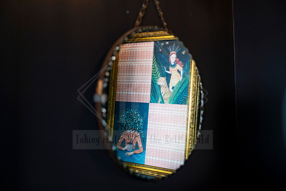 Reflection in vintage mirror displayed at Sunset Framing & Gallery.