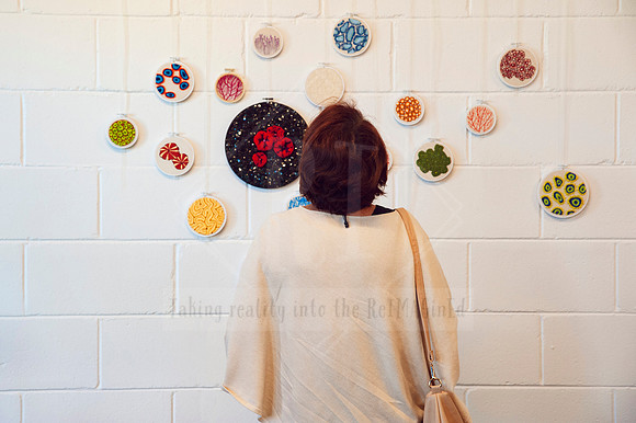 Woman observing colourful wall installation at Sunset Framing & Gallery, part of local creative content shoot.