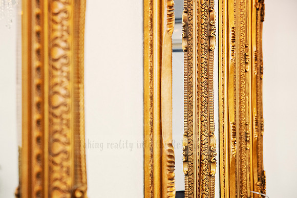 Close-up detail of textured gold mirror frame, capturing luxe salon aesthetics.