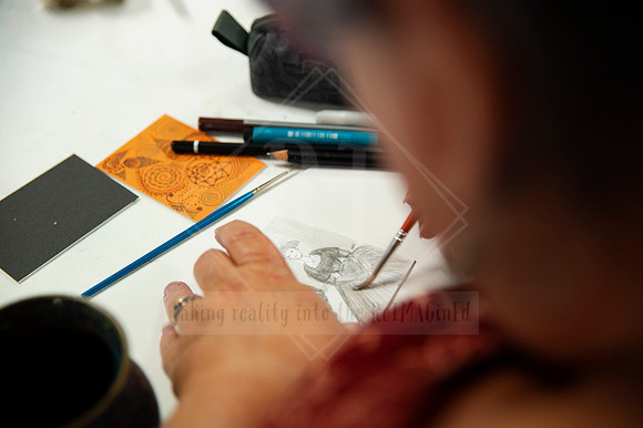 Close-up of artist sketching on paper, photographed in real-time during a creative business workshop.