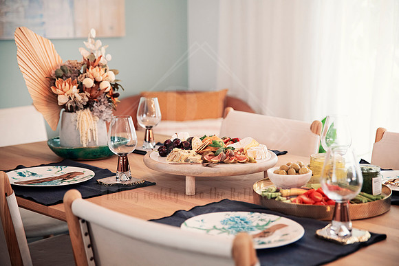 Elegant breakfast table with dried floral centrepiece and two guest place settings.