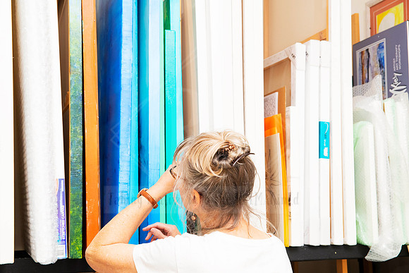 Artist browsing  canvas art in creative workspace, behind-the-scenes moment for arts business content.
