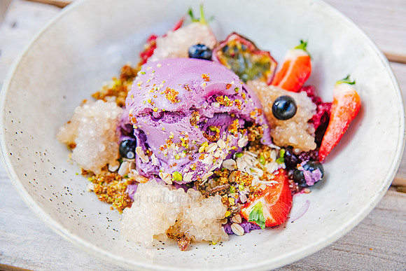 Vibrant granola and fruit smoothie bowl with edible flowers, styled wellness content for Bron Watson & Co.