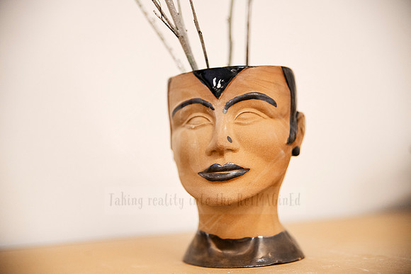 Stylised ceramic head sculpture holding brushes, quirky still life for Artwalk’s visual storytelling.