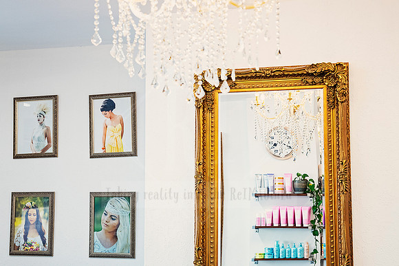 Crystal chandelier details draped across a baroque mirror and ticking wall clock.