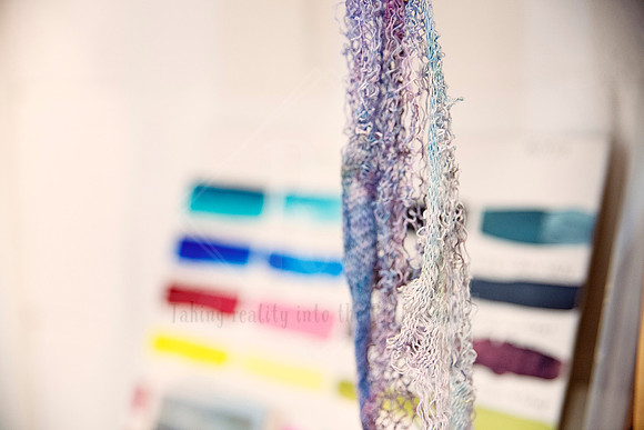 Textile artwork with tactile yarns and colour samples in soft focus, styled studio shot for Yvonne Kiely Art.