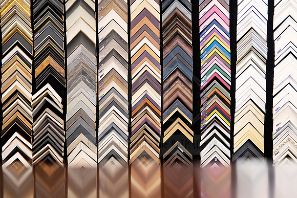 Framing sample wall at Sunset Framing & Gallery, showcasing a wide array of corner mouldings in different finishes.