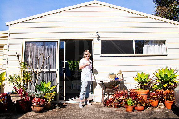 Exterior image of artist standing outside her home studio in natural light, captured for authentic business branding.